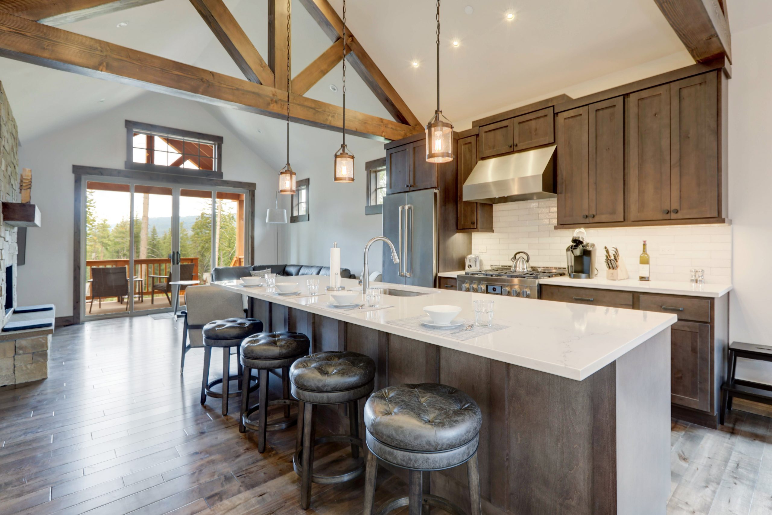 Amazing modern and rustic luxury kitchen with vaulted ceiling and wooden beams, long island with white quarts countertop and dark wood cabinets.